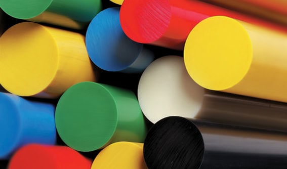 Close-up of colorful plastic rods arranged in a cluster. The rods are smooth and cylindrical, in shades of red, yellow, green, blue, white, and black, with their round ends facing the viewer.